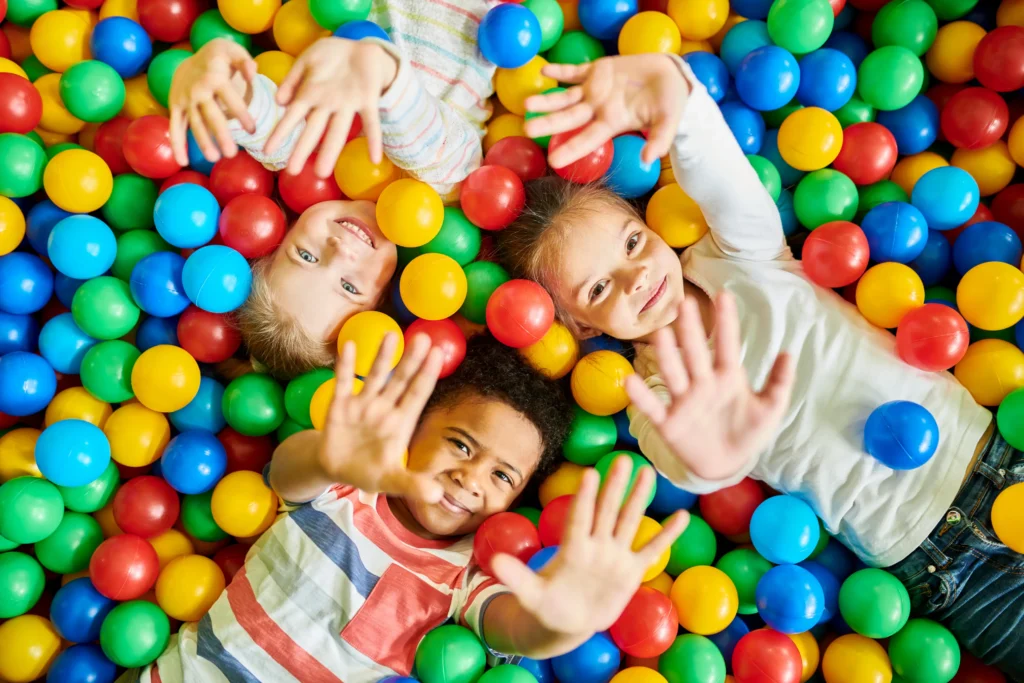 Children playing in a colorful ball pit